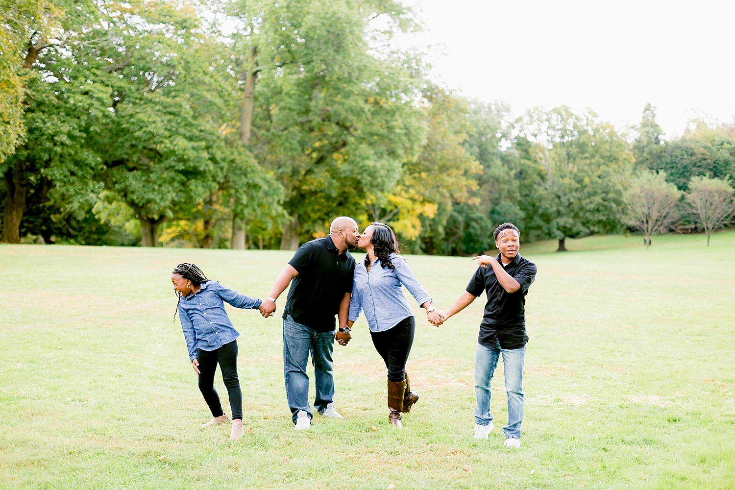 family of four walk across an open field in a photo